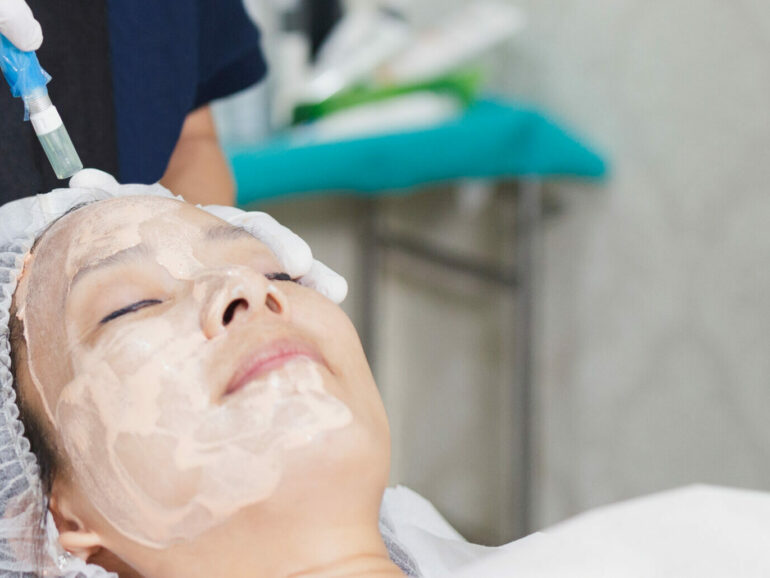 Woman having stimulating facial treatment at professional clinic