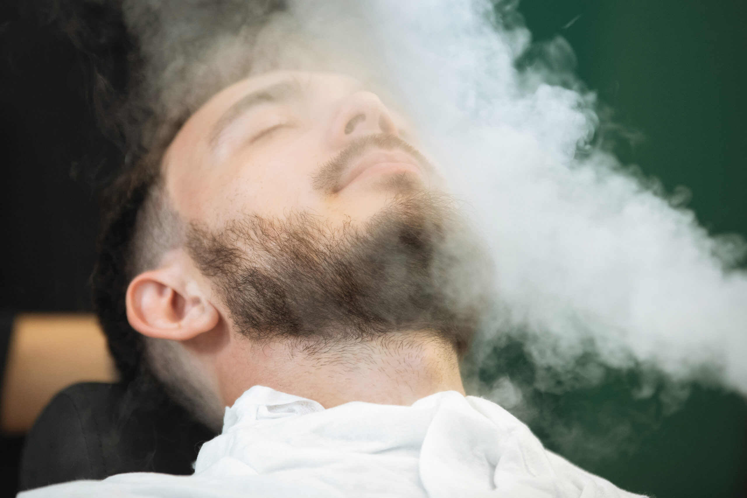 Vaporizer for the face in the hairdresser. Steam beard softening in preparation for shaving. Selective focus, blurred background.